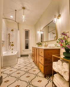 a bathroom with a sink, toilet and bathtub next to a shower stall filled with towels