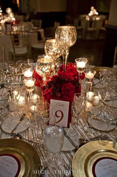 the table is set with wine glasses and candles