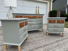 two gray dressers sitting on top of a rug in front of a garage