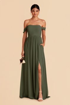 a woman wearing a green dress with thigh high slits and an off the shoulder top