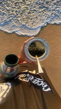 a person is holding a plate on the beach