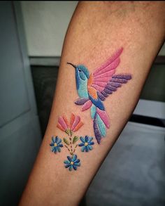 a colorful hummingbird with flowers on the left arm and back of the arm is shown