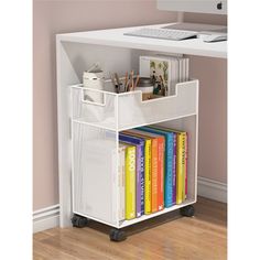 a white book shelf with books on it and a computer desk in the corner behind it