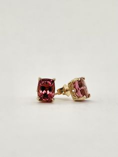 A unique shade of Tourmaline, these emerald cut salmon Tourmalines boast a deep reddish purple hue, that are complemented by the warming tones of 14k yellow gold.  Each stone is a 6 x 8 emerald cut, for a total carat weight of 3.30ct, all prong set into a decorative scroll mounting with friction back closures. Emerald-cut Tourmaline Wedding Jewelry, Formal Yellow Gold Tourmaline Earrings, Pink Tourmaline Ring Emerald Cut, Yellow Gold Tourmaline Gemstone Earrings, Pink Emerald-cut Tourmaline Jewelry, Tourmaline Earrings, Purple Hues, Emerald Cut, Prong Setting