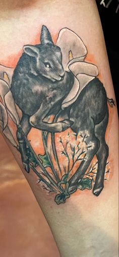 a tattoo with an image of a bull and flowers on it's thigh,