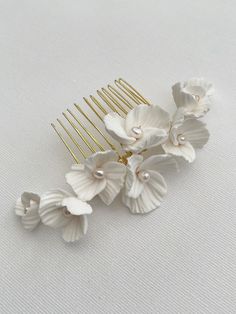 Beautiful bridal hair comb, decorated with ivory clay flowers and freshwater pearls. The haircomb measures approx 14cm x 5cm Available in silver, gold or rose gold colour wire. Order processing time has been extended due to high number of orders, so please DM if you need it posted sooner. As each of our pieces is handmade especially for you, we are unable to accept returns/exchanges Floral Hair Comb, Beautiful Bridal Hair, Hair Comb Bridal, Floral Hair Combs, Headpiece Bridal, Wedding Hair Comb, Bridal Hair Clip, Bridal Comb, Hair Comb Wedding