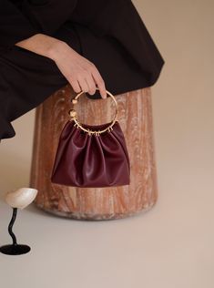 Burgundy Ring Handle Bag - Verafied New York Gold Leather Handheld Evening Bag, Elegant Clutch With Round Handle For Formal Occasions, Elegant Formal Clutch With Round Handle, Elegant Evening Clutch With Round Handle, Chic Formal Evening Bag With Round Handle, Elegant Leather Clutch With Round Handle, Elegant Leather Evening Bag With Round Handle, Elegant Evening Bag With Gold-tone Hardware And Round Handle, Elegant Evening Bag With Metal Hardware