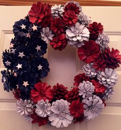 a wreath made out of red, white and blue flowers on the front door to celebrate the fourth of july