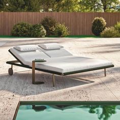 an empty chaise lounge next to a swimming pool