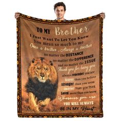 a man holding up a blanket with an image of a lion and the words to my brother