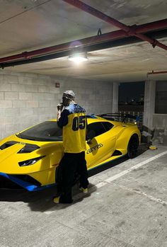 a man standing next to a yellow sports car