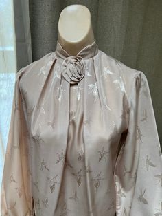 "Pretty sand color dressy blouse is perfect for a professional lady or one part of a formal outfit paired with a dressy skirt or slacks.  No tags of any kind so I am not certain about the size or the fabric.   But I am pretty sure the fabric is a very nice polyester with a matte satin surface.  From the way it fits my size S dress form I would recommend it for a lady who usually wears a size 4 or 6 in a top. Everything about the fabric - texture, color, embossed design - is lovely.  The color is Elegant Spring Wedding Blouse, Beige Feminine Formal Tops, Beige Formal Feminine Tops, Formal Feminine Beige Tops, Elegant Tops For Spring Wedding, Fitted Solid Color Elegant Blouse, Beige Long Sleeve Evening Blouse, Beige Long Sleeve Blouse For Evening, Elegant Fitted Blouse