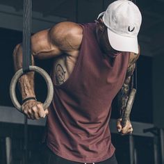 a man with a ring around his neck holding onto a bar in a gym area