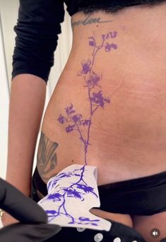 a woman's stomach with tattoos on it and flowers growing out of the side