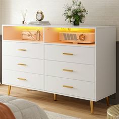 a white dresser with yellow lights on top