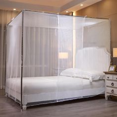 a white bed sitting in a bedroom next to a night stand