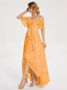 a woman is wearing an orange dress and high heeled sandals with her hand on her head