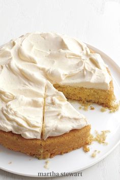 a white plate topped with a cake covered in frosting and sliced into four slices