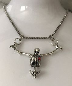 a silver necklace with a skeleton on it