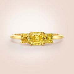 three stone yellow diamond ring on white background