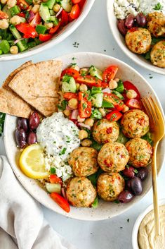 three plates filled with different types of food on top of a white tablecloth next to bowls of salad and pita bread