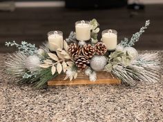 some candles are sitting on a table with pine cones