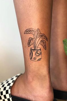 a woman's foot with a plant tattoo on the left side of her leg