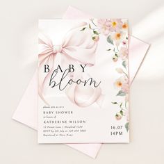 a baby shower is shown with pink flowers and bows on the front, along with an envelope