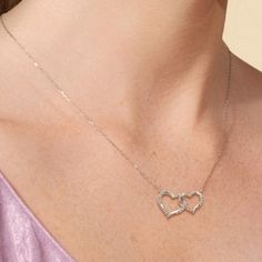 Two twisted hearts intertwined - together, forever. This heart pendant in white gold features a big and small heart cut-out linked together as a symbol of everlasting love. Diamonds adorn the pair of hearts. This necklace can represent the special bond between sisters, mother and child, or couples. Fine Jewelry Double Heart Necklace For Wedding, White Gold Heart Pendant For Promise, White Gold Heart Pendant Jewelry For Promise, White Gold Double Heart Jewelry With Cubic Zirconia, Promise Jewelry With Heart Charm In White Gold, White Gold Promise Jewelry With Heart Charm, Promise Heart Pendant Necklace With Heart Charm, Heart Pendant Necklace With Heart Charm For Promise, Sterling Silver Infinity Heart Necklace For Anniversary