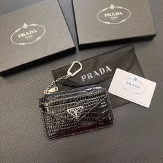 Elevate your everyday essentials with the PRADA Classic Card Holder Wallet. This exquisite accessory, meticulously crafted by the renowned Italian fashion house, exemplifies the perfect blend of luxury, functionality, and timeless style. Features: Premium Materials: Constructed from the finest Saffiano leather, known for its distinctive crosshatch texture and exceptional durability, ensuring your card holder remains pristine through daily use. Sleek Design: Its minimalist aesthetic features clea Prada Card Holder, Brand Card, Keychain Holder, Keychain Ring, Prada Logo, Classic Card, Business Card Case, Card Sleeves, Cross Patterns