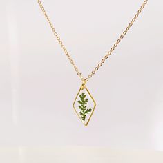 Gold necklace with real pressed fern leaf in resin Terrarium Jewelry An elegant resin necklace with real green hand-picked forest fern. This will be a special gift for a loved one, as ferns symbolize sincerity towards others. If you are giving someone a fern as a gift, you are giving them the hope that they will have confidence, shelters, wealth, and happiness. This is a great plant to give someone that you really care about. Charm size: 24x9mm (0.94 * 0.35 inch) Non-tarnished gold-plated stainl Delicate Green Jewelry With Birth Flower, Delicate Green Birth Flower Jewelry, Green Flower Pendant Necklace As Gift, Green Flower Pendant Necklace For Gift, Minimalist Pressed Flower Necklace For Mom, Delicate Green Necklace For Gift, Minimalist Pressed Flowers Necklace Gift For Mom, Delicate Green Charm Necklace As Gift, Delicate Green Charm Necklace For Gift