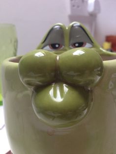 a close up of a ceramic cup with a face on it