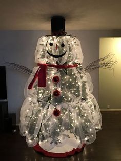 a lighted christmas tree with a snowman on top