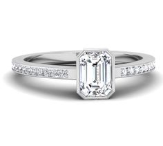 an emerald cut diamond engagement ring with channeled shoulders