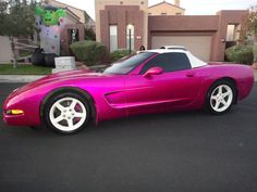 a pink sports car parked in front of a house