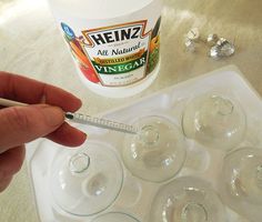 a person is holding a pen in front of an ice tray with wine glasses on it