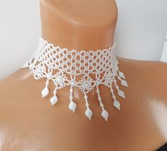 a close up of a mannequin wearing a white necklace