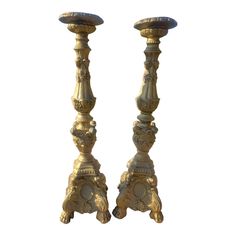 two gold colored candlesticks sitting next to each other