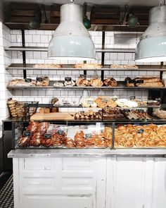 a bakery filled with lots of different types of breads and pastries on display