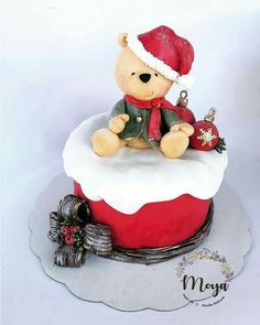 a teddy bear sitting on top of a christmas cake