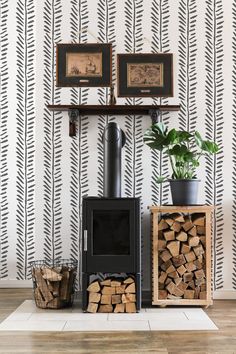 a fireplace with logs stacked on top of it in front of a wallpapered background