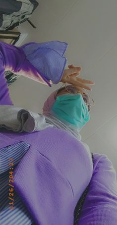 a mannequin wearing a surgical mask and purple dress is posed for the camera