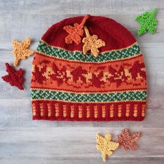 a knitted hat with crochet stars and leaves on the side next to it