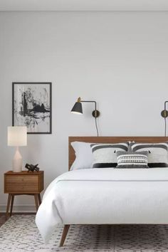 Bedroom features mounted reading lights, two bedside table, and a soft rug. Simple Sleek Bedroom Ideas, Mid Century Modern Master Bedrooms 2022, Modern Contemporary Bedroom Minimalist, Modern Bedroom Scandinavian, Modern Century Bedroom Ideas, Midcentury Modern Scandinavian Bedroom, Scandinavian Bedroom Ikea, Silver Accents Bedroom, Bedroom Design Scandinavian Style