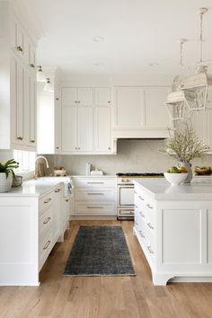 a kitchen with white cabinets and wood flooring is pictured in this image from the front view