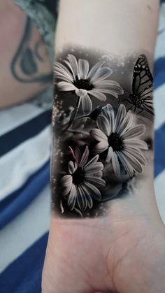 a woman's arm with flowers and a butterfly on it