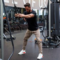 a man is in the gym doing pull ups with an exercise rope on one hand