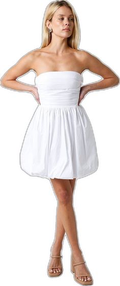 a woman in a white dress is posing for the camera with her hands on her hips