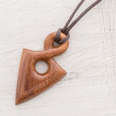 a wooden triangle shaped pendant on a string