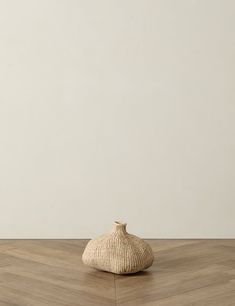 a white vase sitting on top of a wooden floor